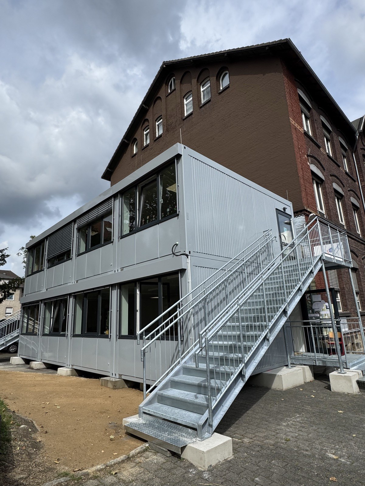 Container-Neubau neben dem alten Schulgebäude
