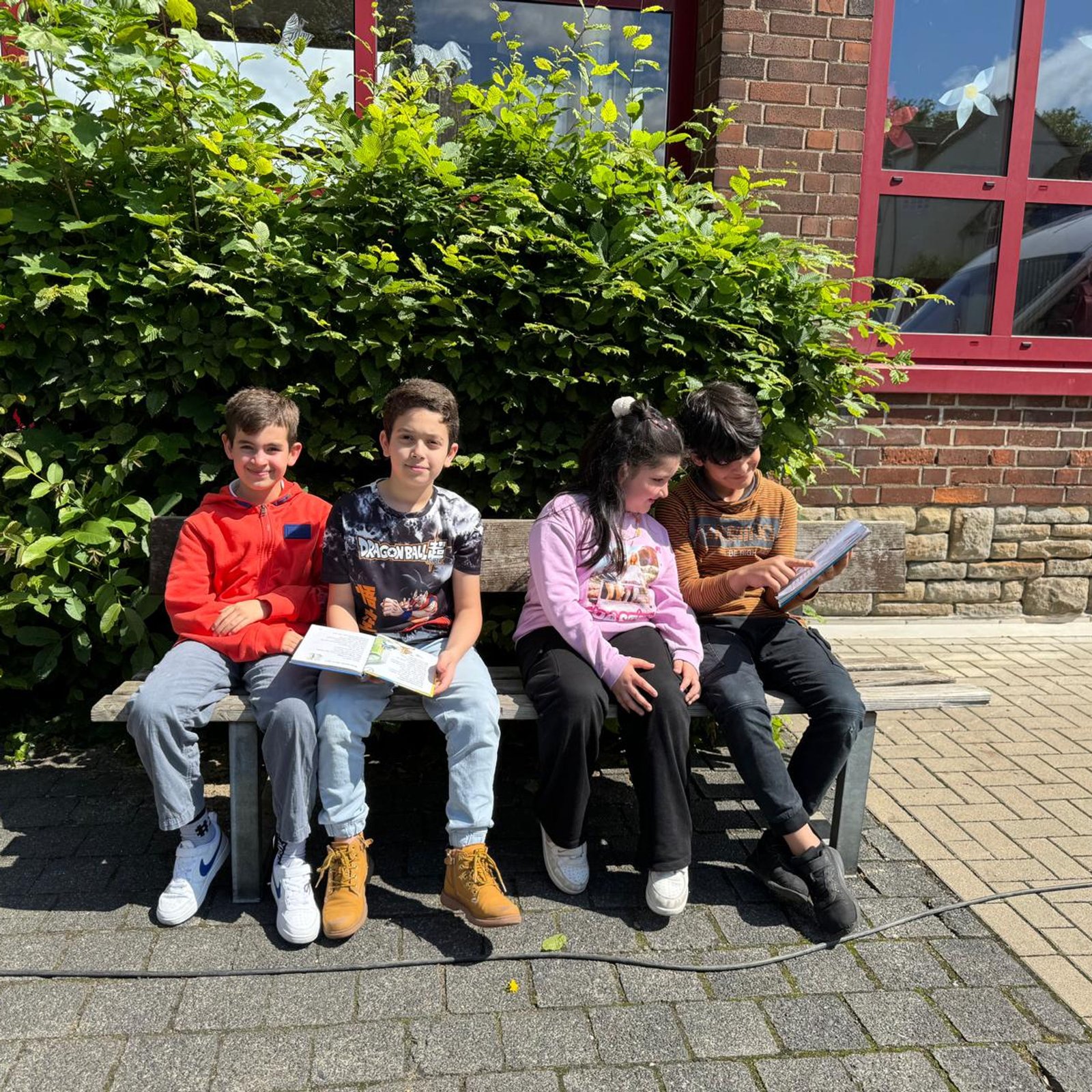 Kinder lesen auf Bank